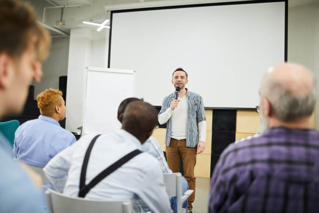 Man overcoming public speaking fears in front of professional networking group